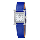 Hermes watch with blue strap on a light gray background