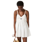 Woman wearing a white dress with a beige background