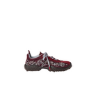 A single low-top sneaker shown in profile against a solid light beige background. The shoe features a deep burgundy suede upper embellished with silver rhinestones, a chunky dark brown textured sole, and light gray laces.
