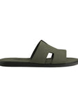 Green sandal with a black sole on a light gray background