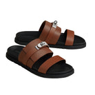 Brown sandals with black soles on a light beige background