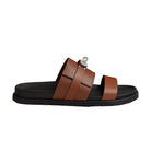 Brown sandal with black sole on a beige background