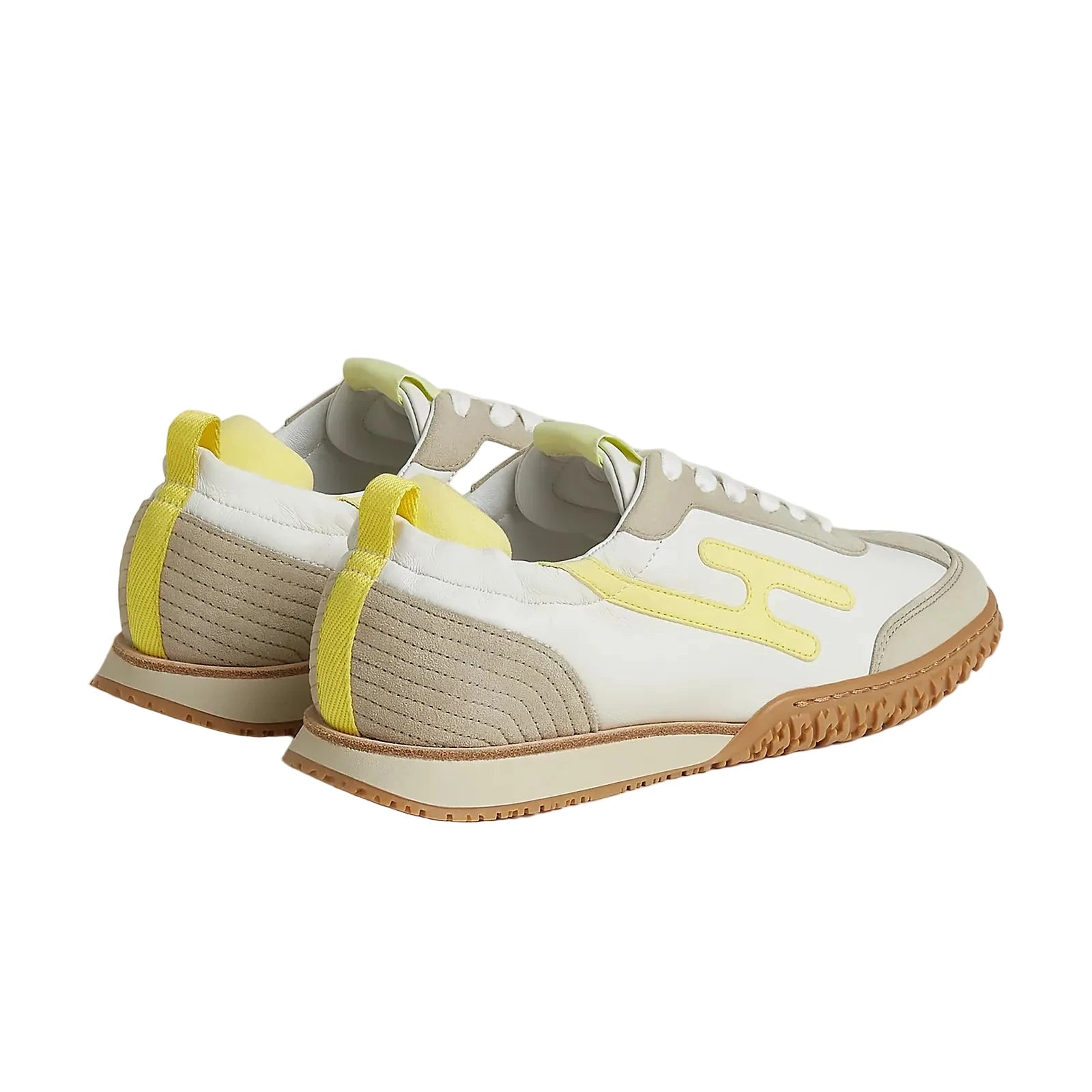 White sneakers with yellow accents on a light beige background