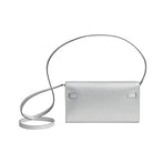 Silver handbag with a strap on a light gray background