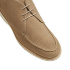 Beige suede shoe with white laces on a light background