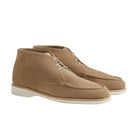 Pair of tan suede shoes on a light beige background