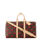 Designer handbag with cherry pattern and beige strap on a white background
