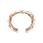 Rose gold ring with intricate design on a white background