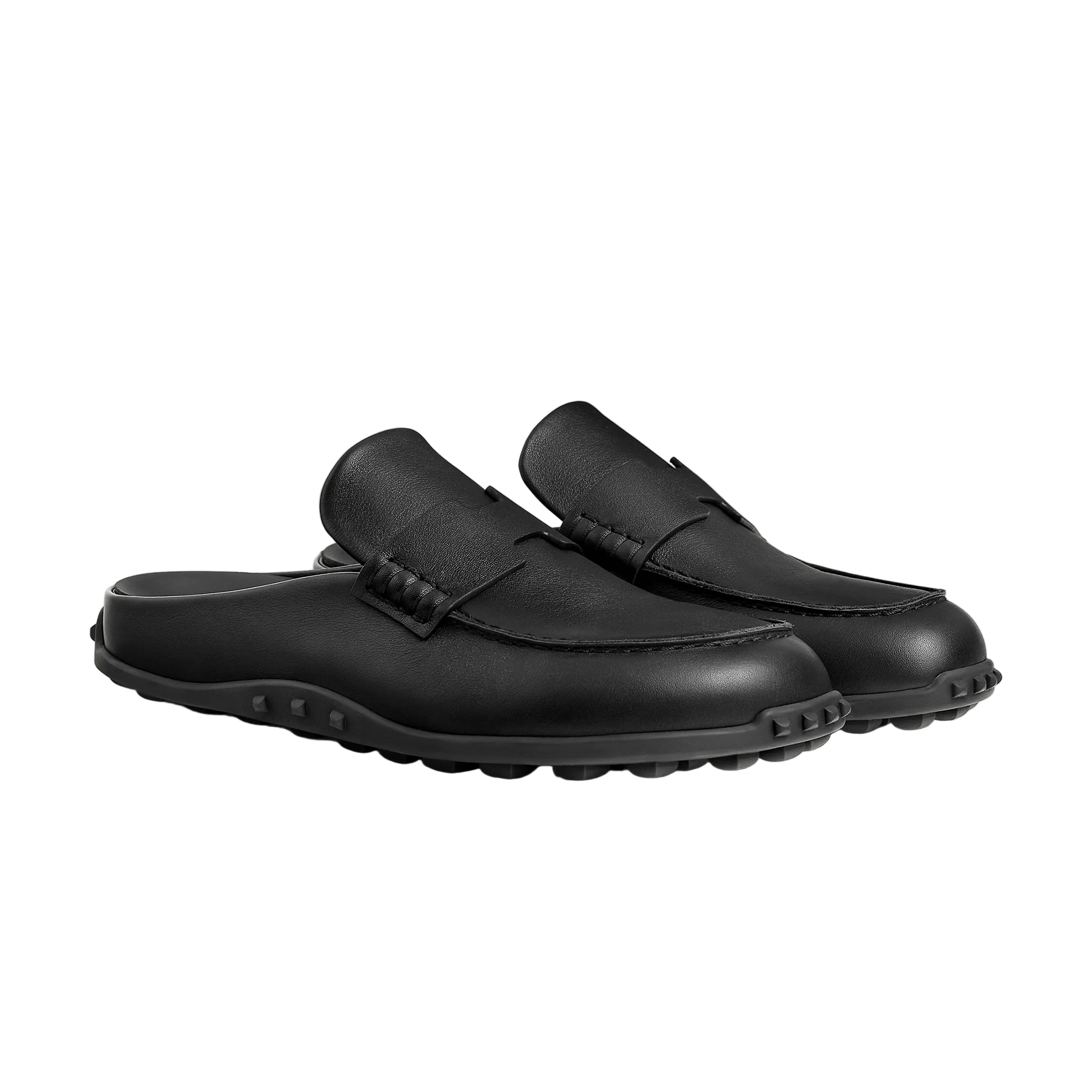 Pair of black loafers on a light beige background