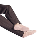 Person wearing pink sneakers with a plain background