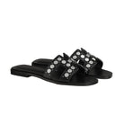 Black sandals with silver studs on a light gray background
