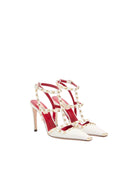 White high-heeled shoes with red accents and pearl-like embellishments on a white background