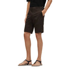 Person wearing brown shorts on a beige background