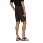 Person wearing brown shorts on a beige background