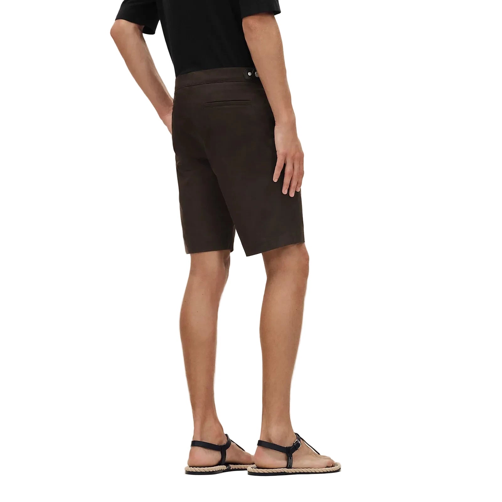 Person wearing brown shorts on a beige background