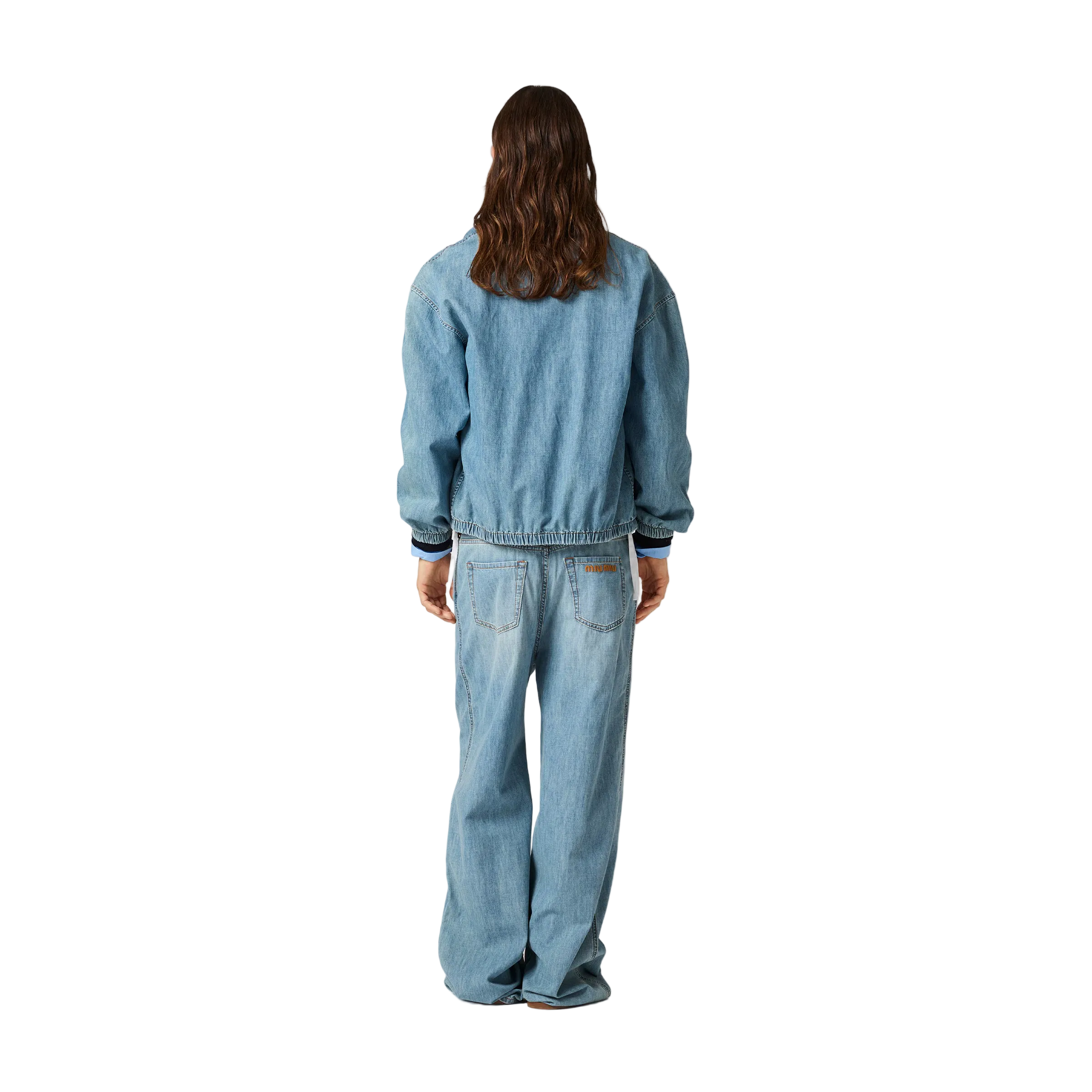 Person wearing a blue denim outfit on a plain background