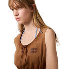 Woman wearing a brown sleeveless top with 'miu miu' logo against a plain background