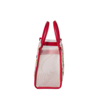 Small transparent bag with red handles on a beige background