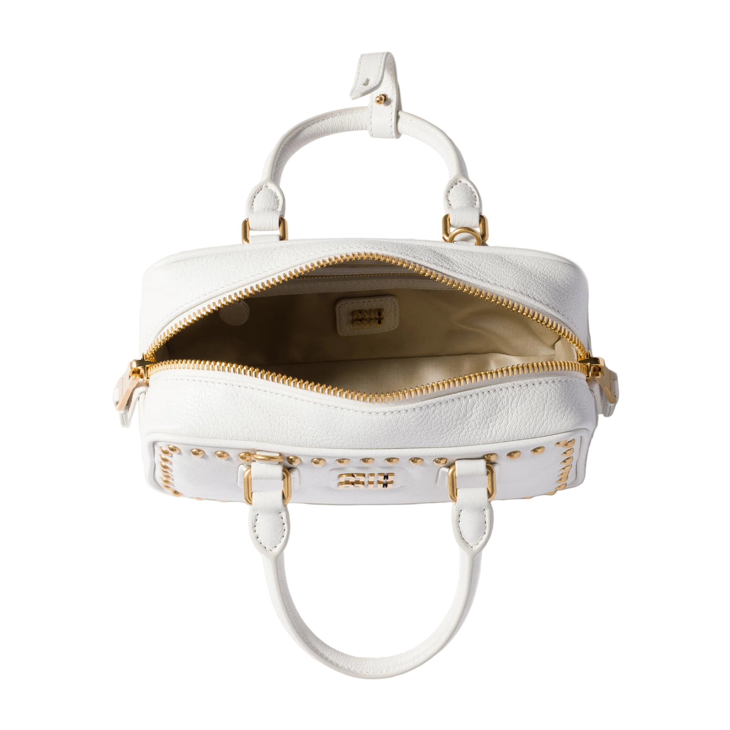 A white leather handbag with gold-tone hardware, shown open from a top-down view against a light beige background.