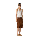 Woman wearing a white tank top and brown skirt on a beige background