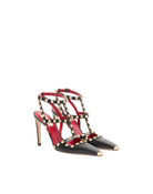 Black high-heeled shoes with red interior and gold accents on a white background