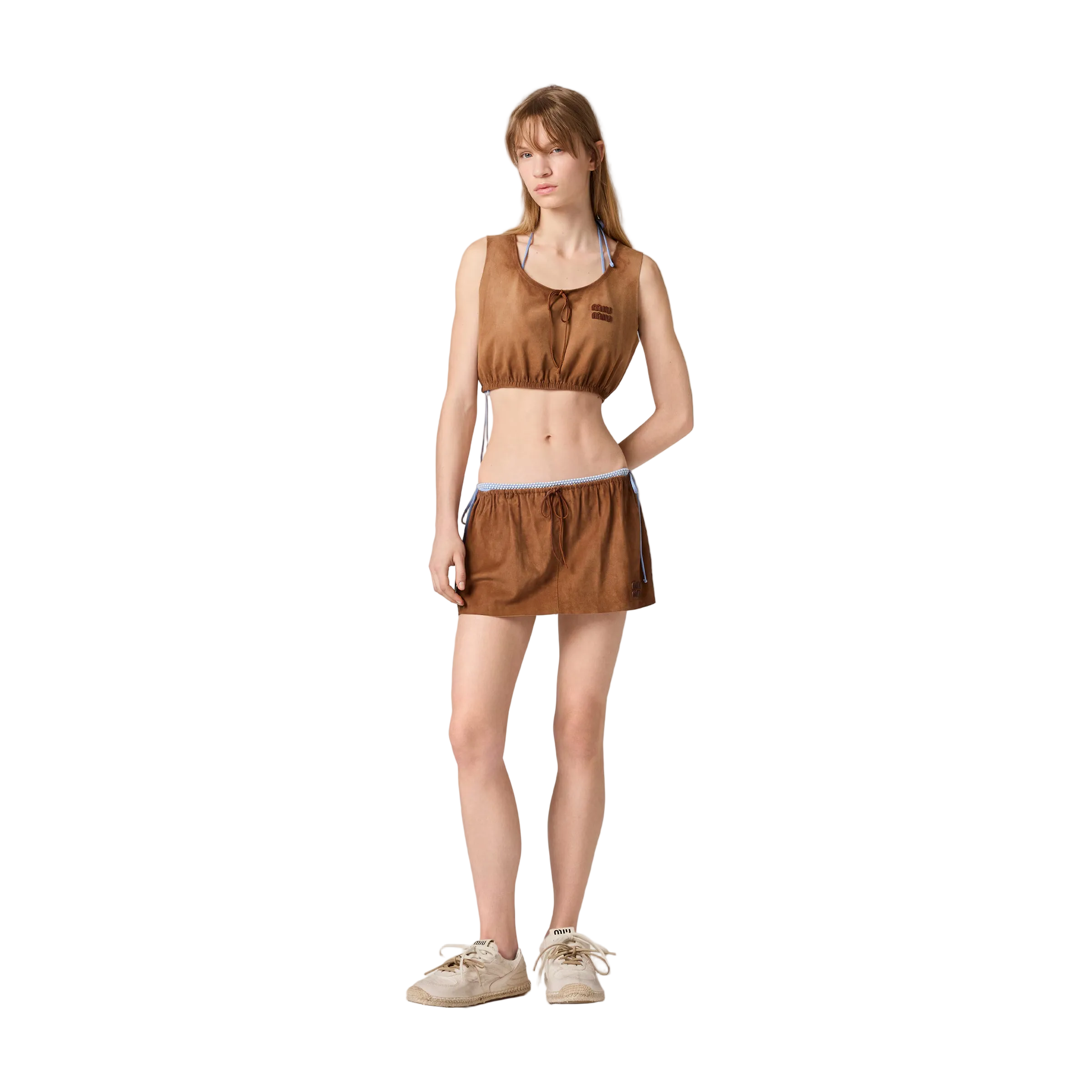 Woman wearing a brown sleeveless top and skirt set on a beige background